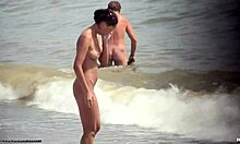 Ragazza nuda dai capelli scuri che cammina nuda su una spiaggia