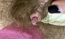 Extremt närbilde av en stor klitoris fitta som gnuggas och sprutas
